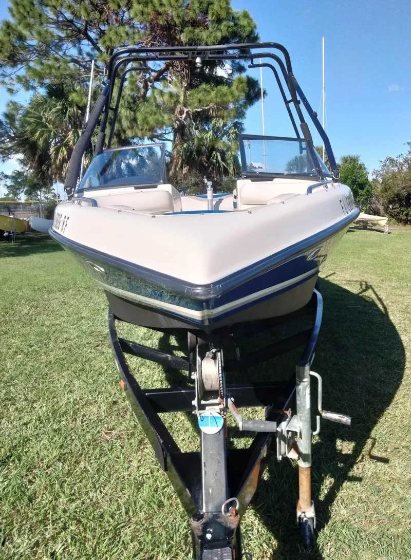 Slide: The Image of 2001 Tigé 21i boat on trailer, parked on grass with trees in background. - 3