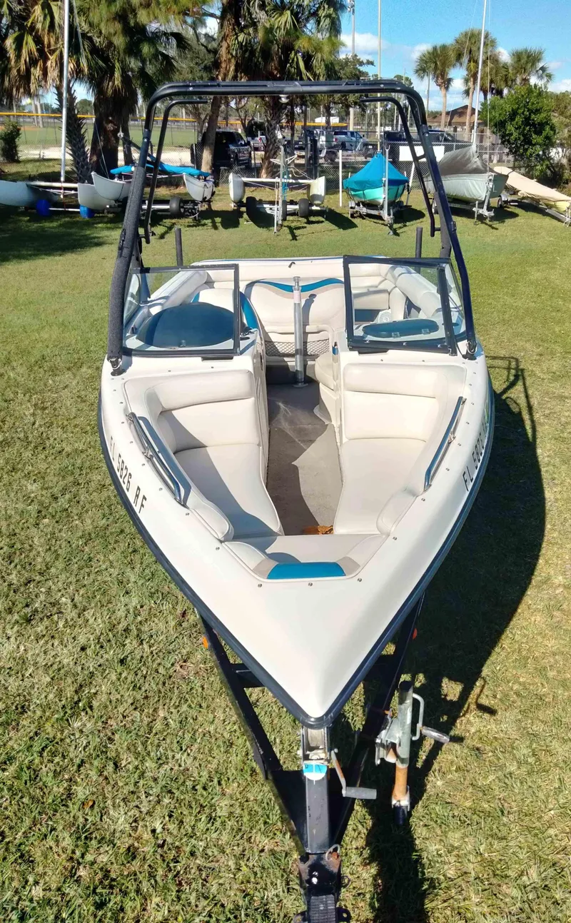 Slide: The Image of 2001 Tigé 21i boat on grass, featuring open bow seating and a wakeboard tower. - 4