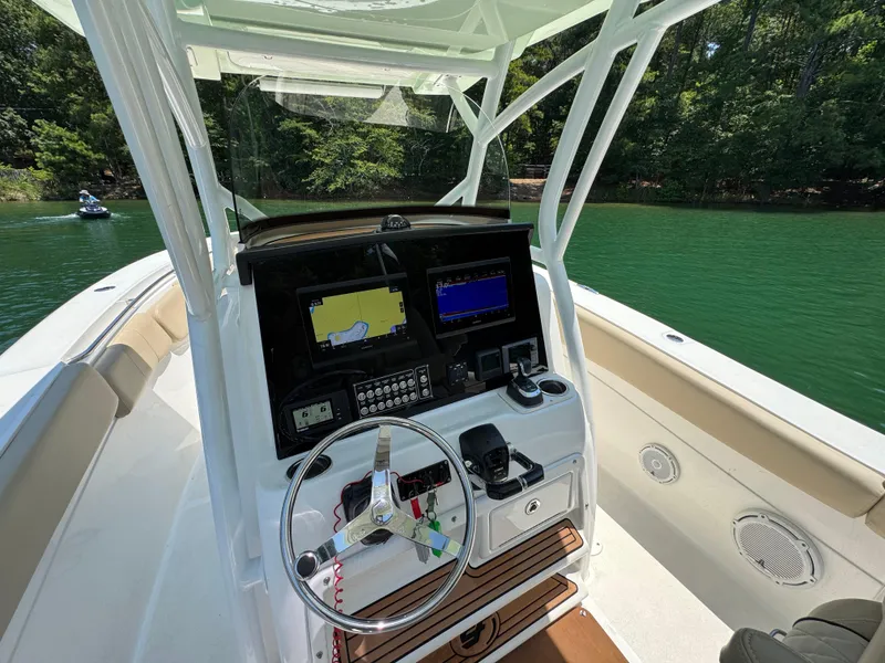 Slide: The Image of 2017 Sea Fox 288 Commander boat dashboard with navigation screens on a serene lake. - 11
