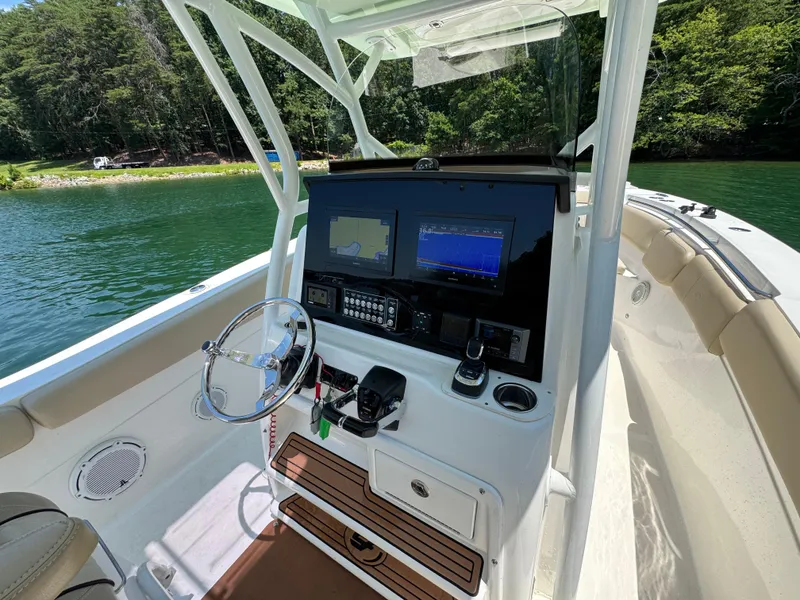 Slide: The Image of 2017 Sea Fox 288 Commander boat dashboard with navigation screens and steering wheel on a sunny day. - 12
