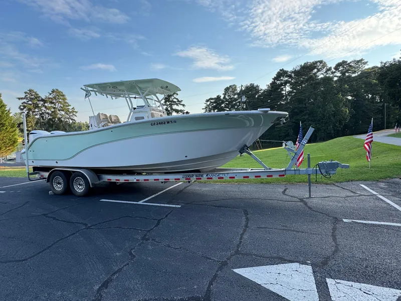 Slide: The Image of 2017 Sea Fox 288 Commander boat on trailer, parked in a lot with flags. - 18