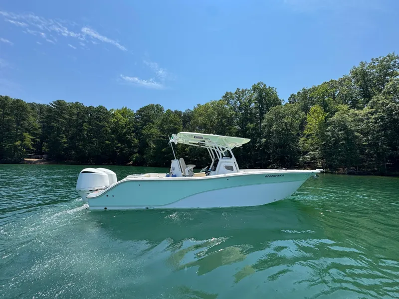 Slide: The Image of 2017 Sea Fox 288 Commander boat on clear water, surrounded by lush trees. - 2