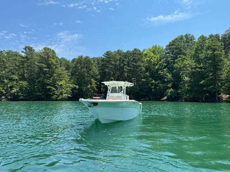 Slide: The Image of 2017 Sea Fox 288 Commander boat on a serene lake with lush green forest backdrop. - 3