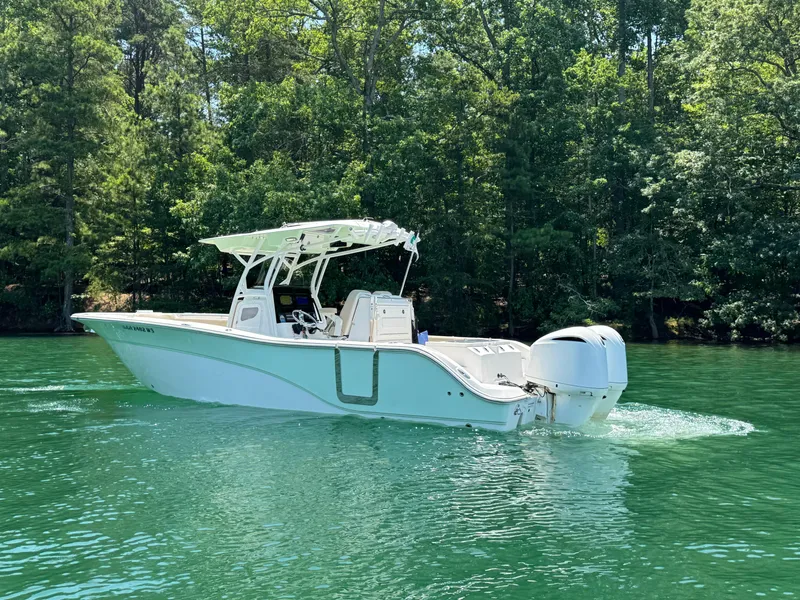 Slide: The Image of 2017 Sea Fox 288 Commander boat cruising on a serene lake with lush green trees. - 8