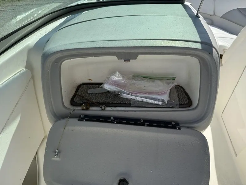 Slide: The Image of Storage compartment in a 2007 Chaparral 276 SSX boat, containing plastic bags and accessories. - 18