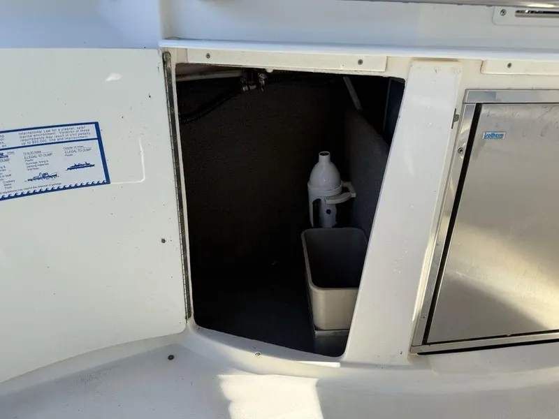 Slide: The Image of Storage compartment on a 2007 Chaparral 276 SSX boat with cleaning supplies. - 23
