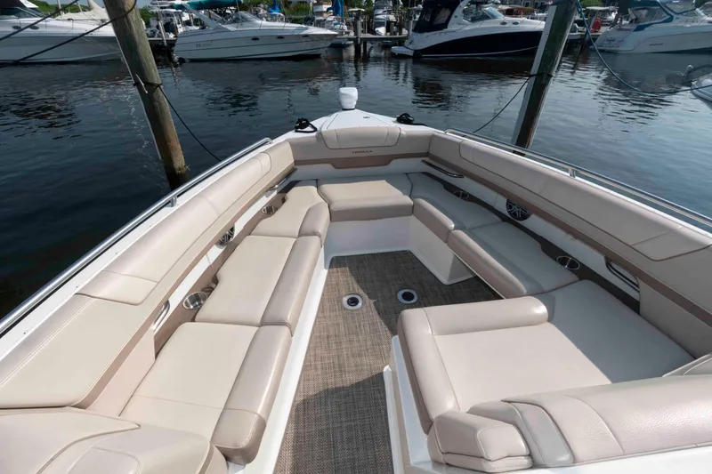 Slide: The Image of 2016 Formula 330 Crossover Bowrider with spacious seating, docked among other boats. - 18