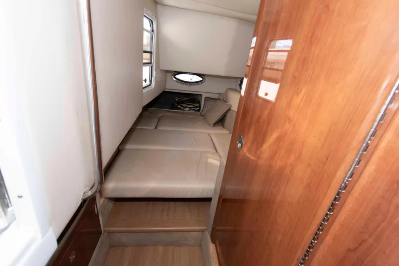 Slide: The Image of 2016 Formula 330 Crossover Bowrider cabin interior with cozy bed and wooden accents. - 19