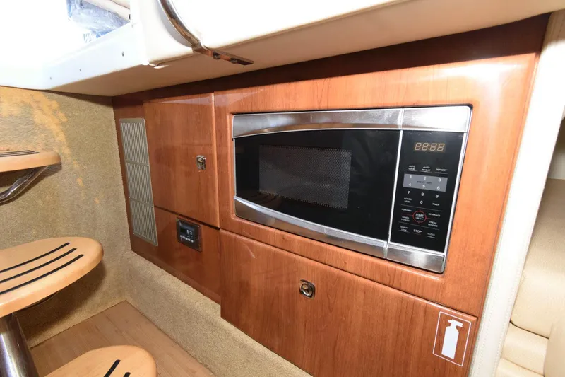 Slide: The Image of 2016 Formula 330 Crossover Bowrider interior with built-in microwave and wooden cabinetry. - 20