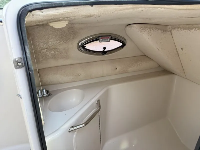 Slide: The Image of Interior of a 2005 Sea Ray 240 Sundeck boat, featuring a compact sink and porthole. - 18