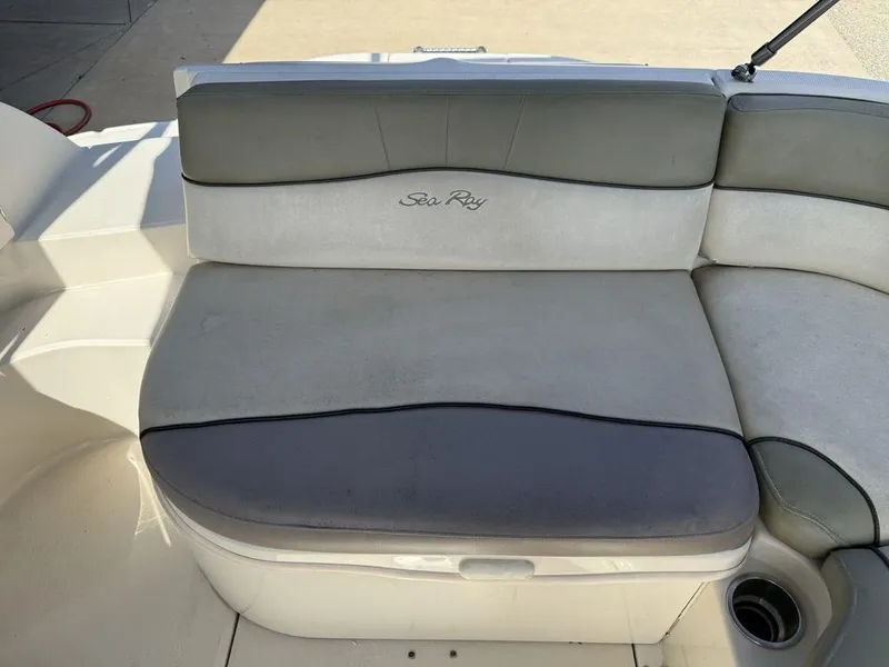 Slide: The Image of 2005 Sea Ray 240 Sundeck boat seating with gray upholstery and cup holder. - 22