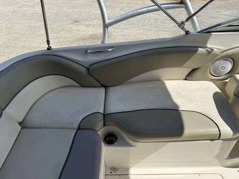 Slide: The Image of 2005 Sea Ray 240 Sundeck interior seating with beige and gray upholstery. - 23