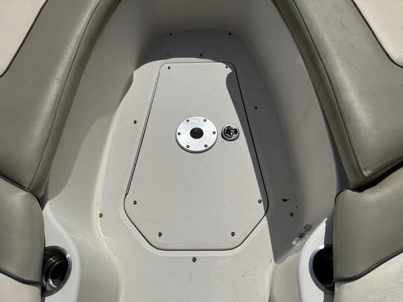 Slide: The Image of 2005 Sea Ray 240 Sundeck interior seating area with cup holders and storage compartment. - 26