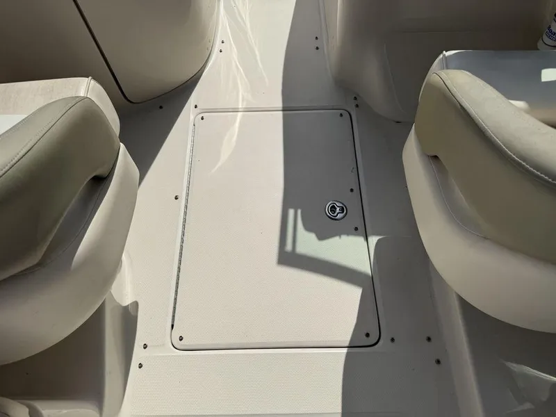 Slide: The Image of 2005 Sea Ray 240 Sundeck interior with beige seating and floor compartment. - 29