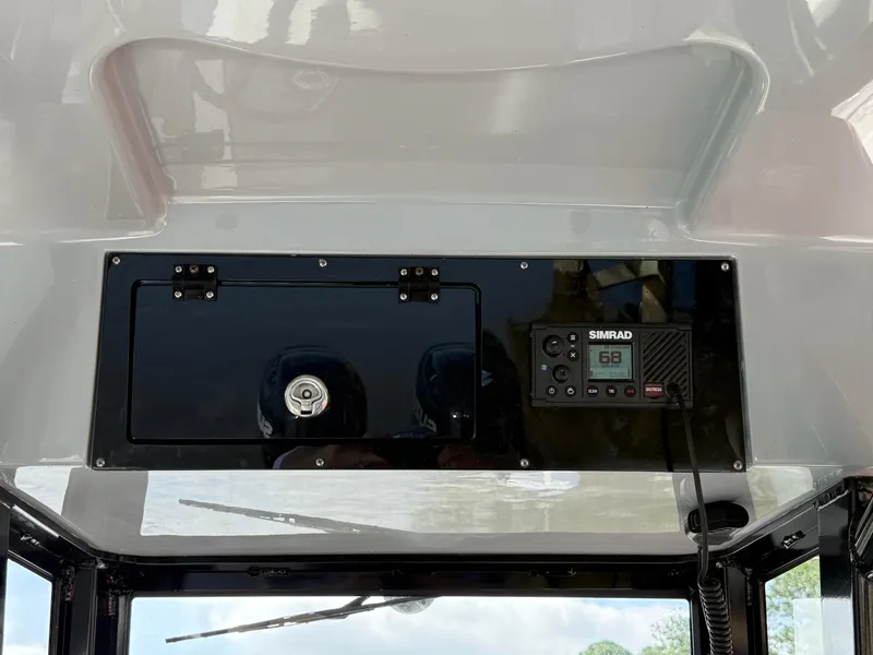 Slide: The Image of 2024 Sea Pro 262DLX boat dashboard with Simrad electronics and storage compartment. - 16