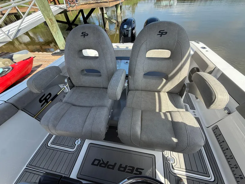 Slide: The Image of 2024 Sea Pro 262DLX boat seats, gray upholstery, docked by water. - 18
