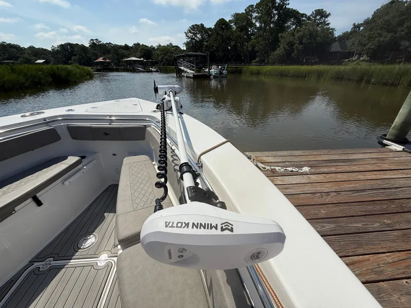 Slide: The Image of 2024 Sea Pro 262DLX boat docked by a serene river with lush greenery. - 25