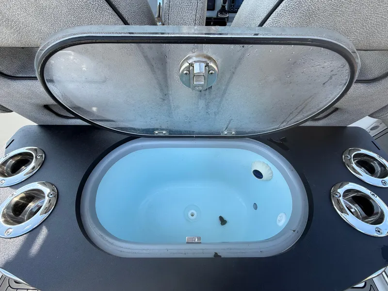 Slide: The Image of Livewell on 2024 Sea Pro 262DLX boat with rod holders and open lid. - 30