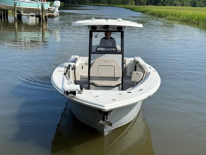 Slide: The Image of 2024 Sea Pro 262DLX boat on calm water, front view, with lush greenery in the background. - 4