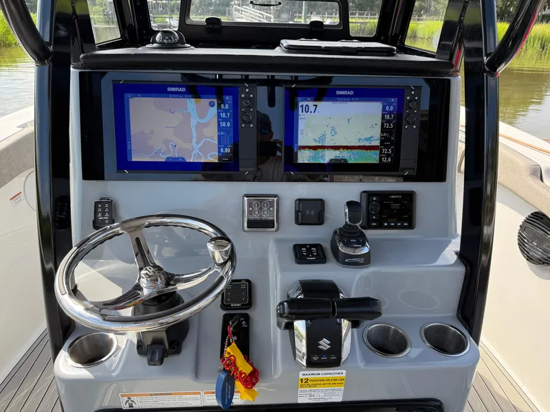 Slide: The Image of 2024 Sea Pro 262DLX boat dashboard with dual Simrad displays and steering wheel. - 6