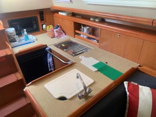 Slide: The Image of Compact kitchen area in a 2008 Hunter 33 sailboat with sink, cutting board, and storage. - 12