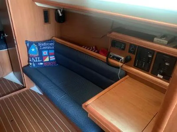 Slide: The Image of Interior of 2008 Hunter 33 sailboat with blue seating and nautical-themed pillow. - 15