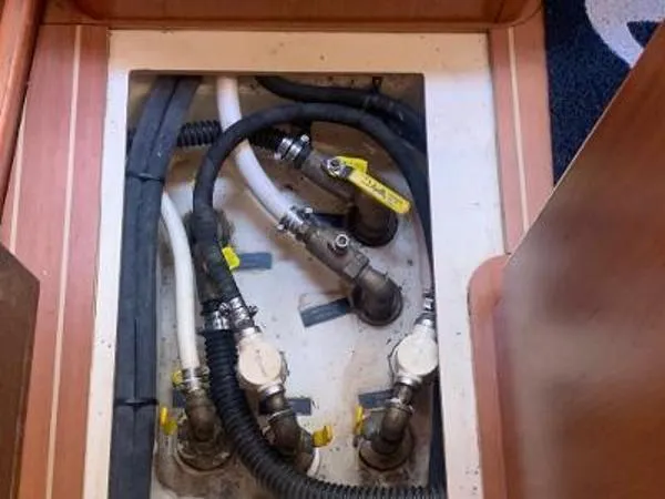 Slide: The Image of Plumbing system inside a 2008 Hunter 33 boat, featuring hoses and valves. - 16