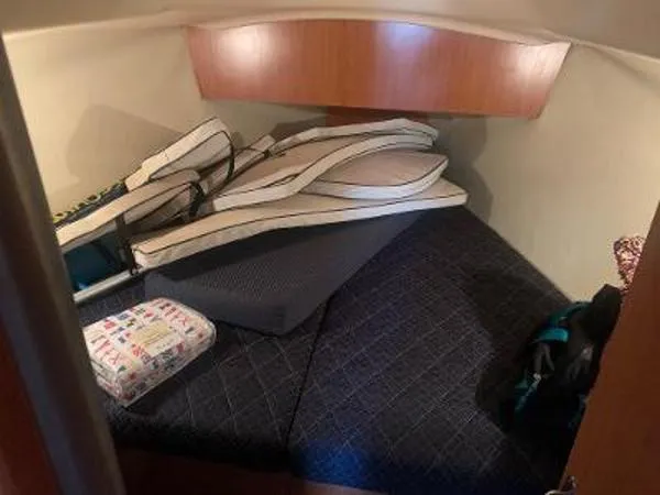 Slide: The Image of 2008 Hunter 33 boat cabin with cushions and storage items. - 17