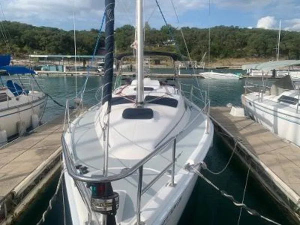 Slide: The Image of 2008 Hunter 33 sailboat docked at marina, surrounded by other boats. - 2