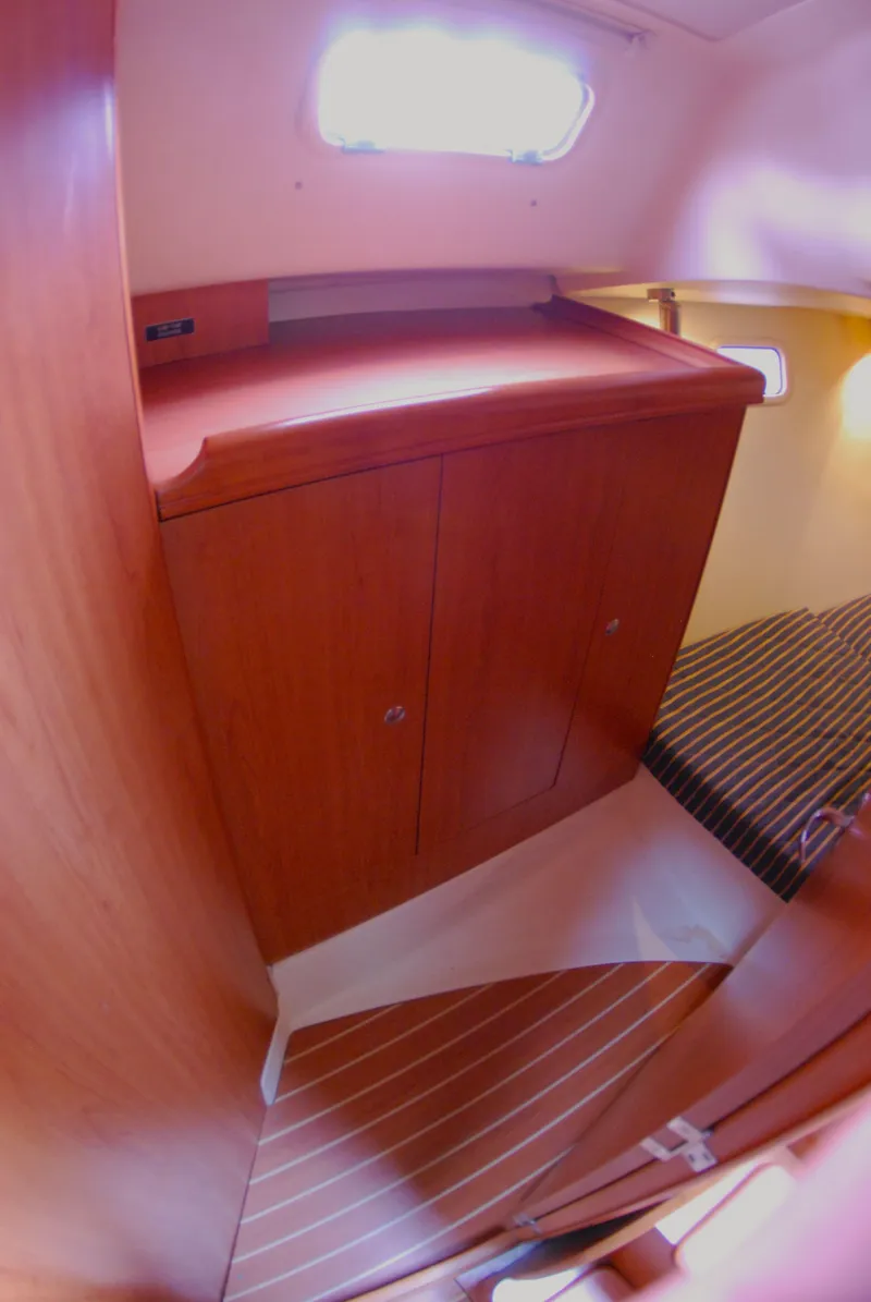 Slide: The Image of Interior of 2008 Hunter 33 sailboat with wooden cabinetry and striped bedding. - 20