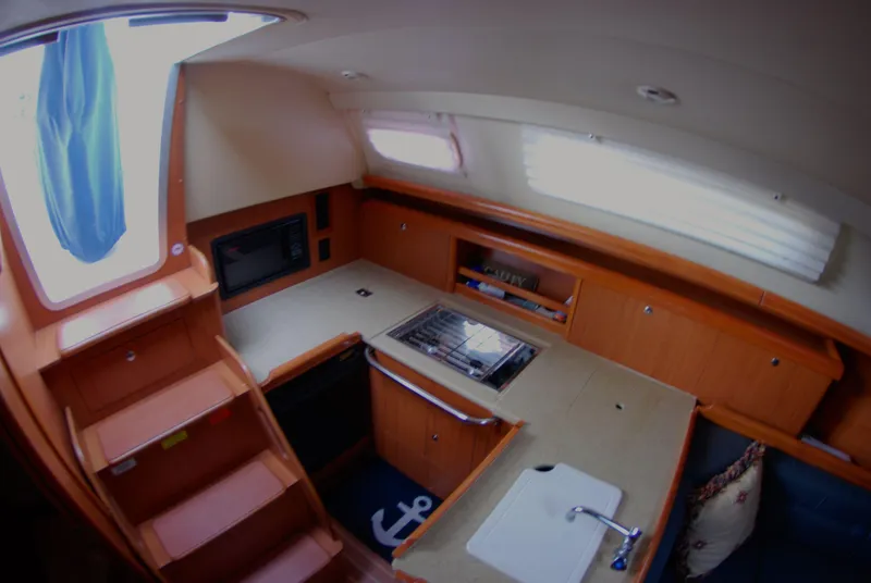 Slide: The Image of Interior of 2008 Hunter 33 sailboat kitchen with stove, sink, and wooden cabinetry. - 25