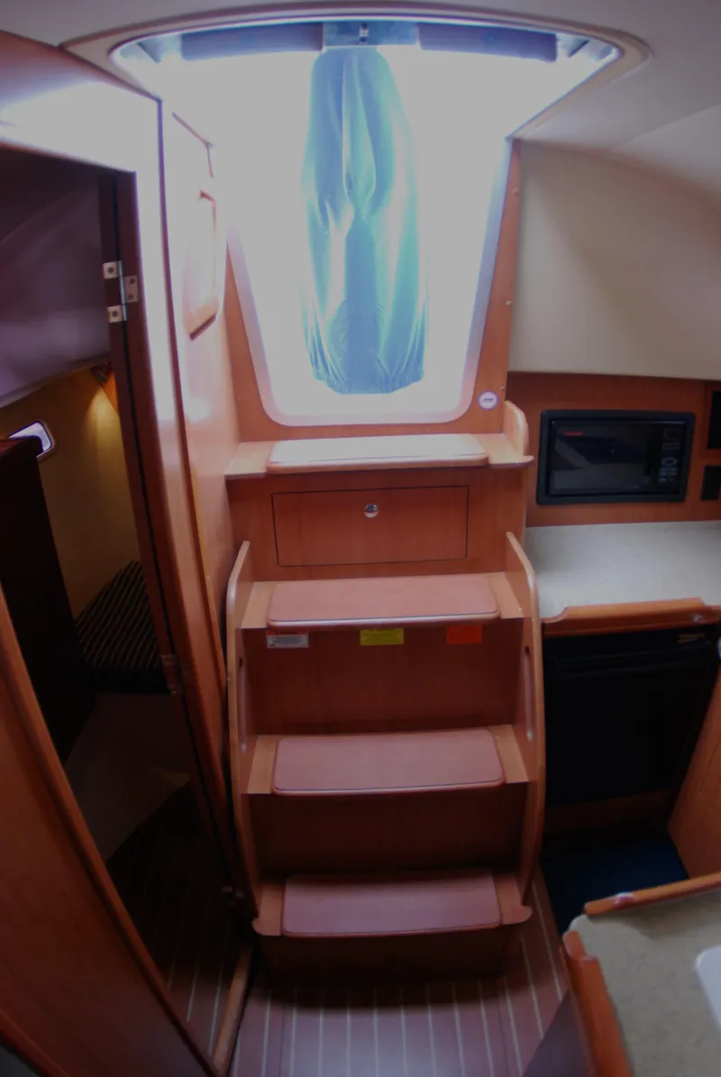 Slide: The Image of Interior of 2008 Hunter 33 sailboat with wooden steps and skylight. - 26