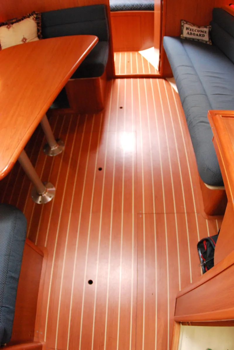 Slide: The Image of Interior of a 2008 Hunter 33 sailboat with wood flooring and cushioned seating. - 27