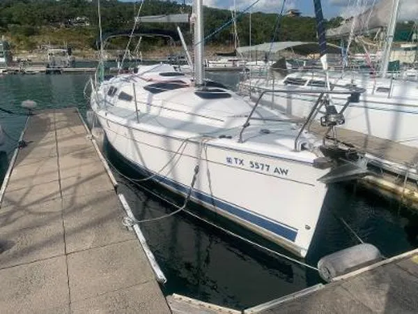 Slide: The Image of 2008 Hunter 33 sailboat docked at marina, side view with registration number visible. - 3