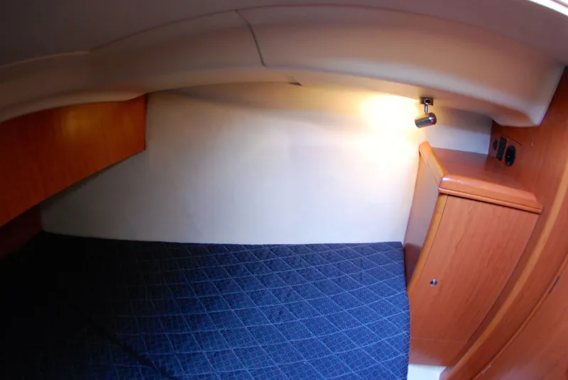 Slide: The Image of 2008 Hunter 33 yacht interior cabin with wooden cabinetry and blue bedding. - 32