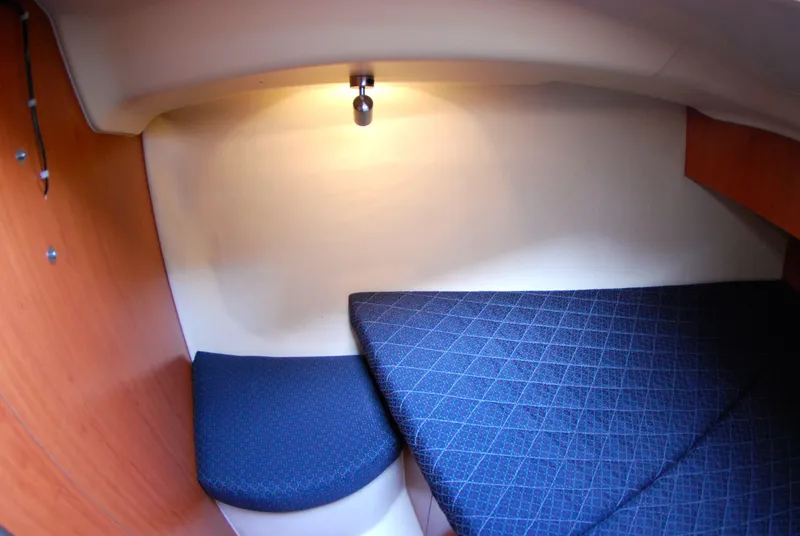 Slide: The Image of Cozy cabin interior of 2008 Hunter 33 sailboat with blue cushioned seating. - 33