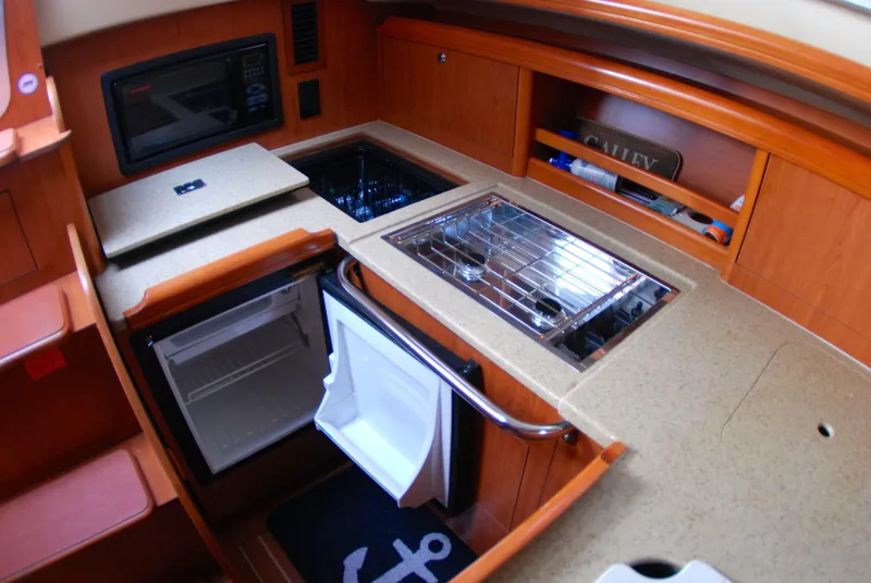 Slide: The Image of Compact galley kitchen in 2008 Hunter 33 sailboat with fridge, stove, and microwave. - 38