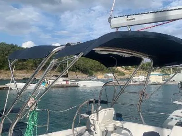 Slide: The Image of 2008 Hunter 33 sailboat with bimini top docked in a marina. - 5