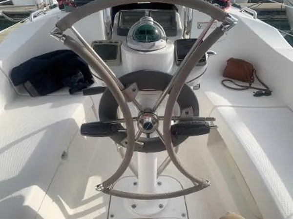 Slide: The Image of Steering wheel of a 2008 Hunter 33 sailboat, featuring a compass and cockpit seating. - 7