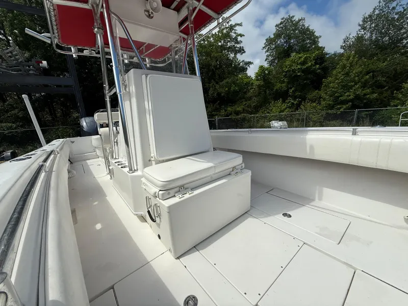 Slide: The Image of 2002 Contender 27 Tournament boat interior with seating and storage, surrounded by lush greenery. - 12