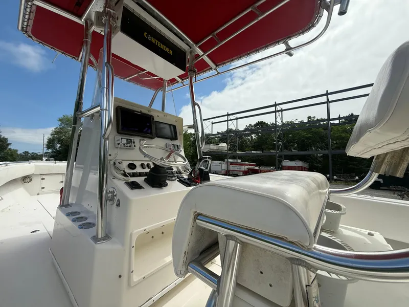 Slide: The Image of 2002 Contender 27 Tournament boat cockpit with steering console and red canopy. - 22