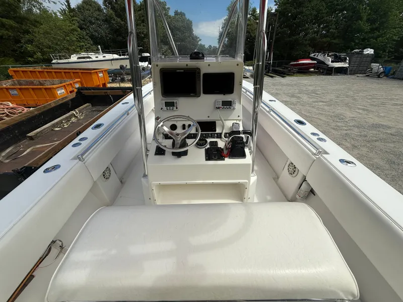 Slide: The Image of 2002 Contender 27 Tournament boat interior with steering console and seating, docked outdoors. - 23