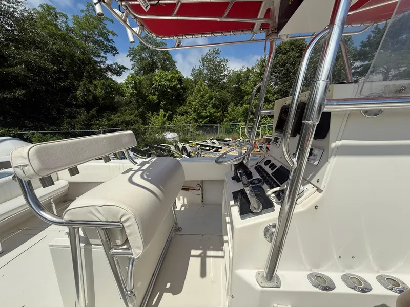 Slide: The Image of 2002 Contender 27 Tournament boat interior with helm, seating, and controls under red canopy. - 27