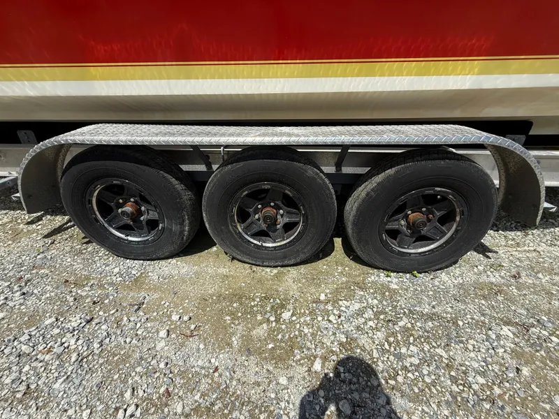 Slide: The Image of Triple-axle trailer for 2002 Contender 27 Tournament boat on gravel surface. - 31