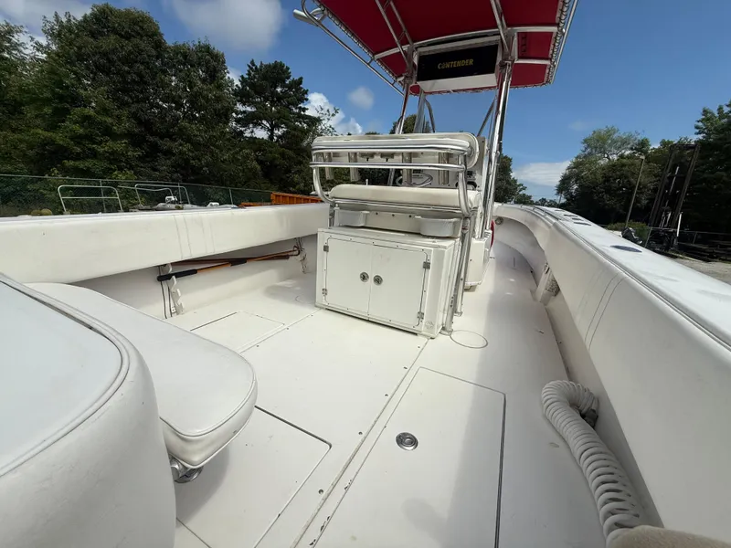 Slide: The Image of 2002 Contender 27 Tournament boat interior with seating and storage, under a red canopy. - 4