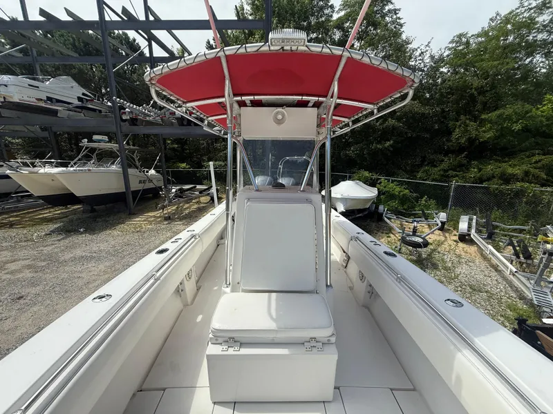 Slide: The Image of 2002 Contender 27 Tournament boat with red canopy, docked in a storage area. - 8