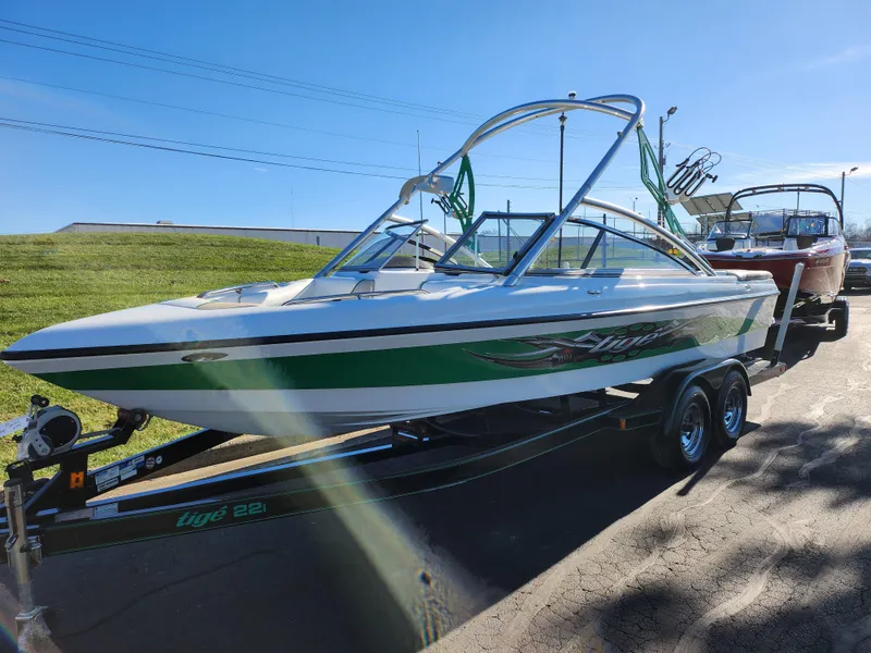 Slide: The Image of 2007 Tigé 22i boat on trailer, green and white design, parked outdoors. - 6