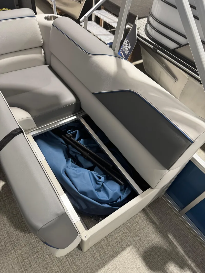 Slide: The Image of 2024 Avalon 1575 23 Venture CR boat seat storage compartment with blue fabric inside. - 8