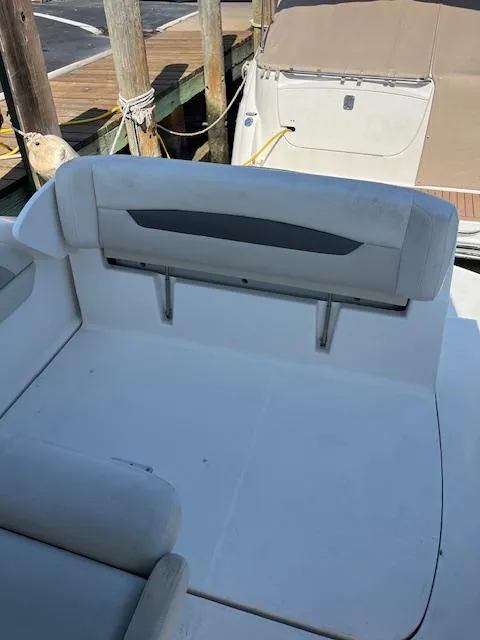 Slide: The Image of 2008 Chaparral Signature 250 boat interior with white seating and dock background. - 10