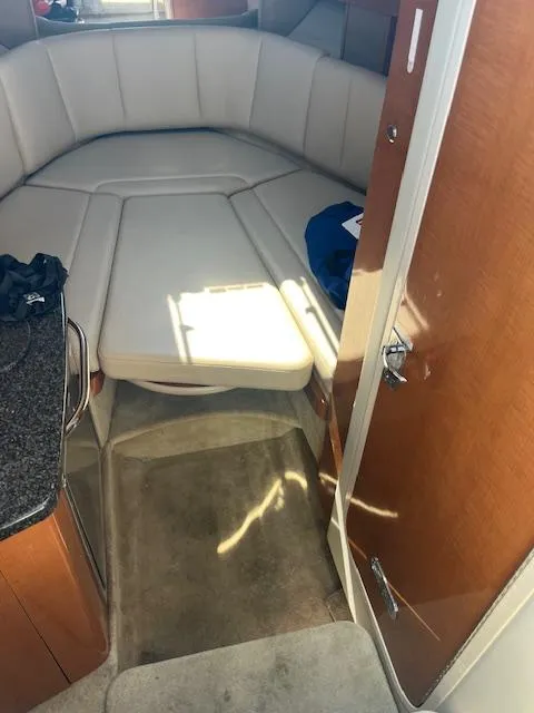 Slide: The Image of 2008 Chaparral Signature 250 cabin interior with beige seating and wooden accents. - 11